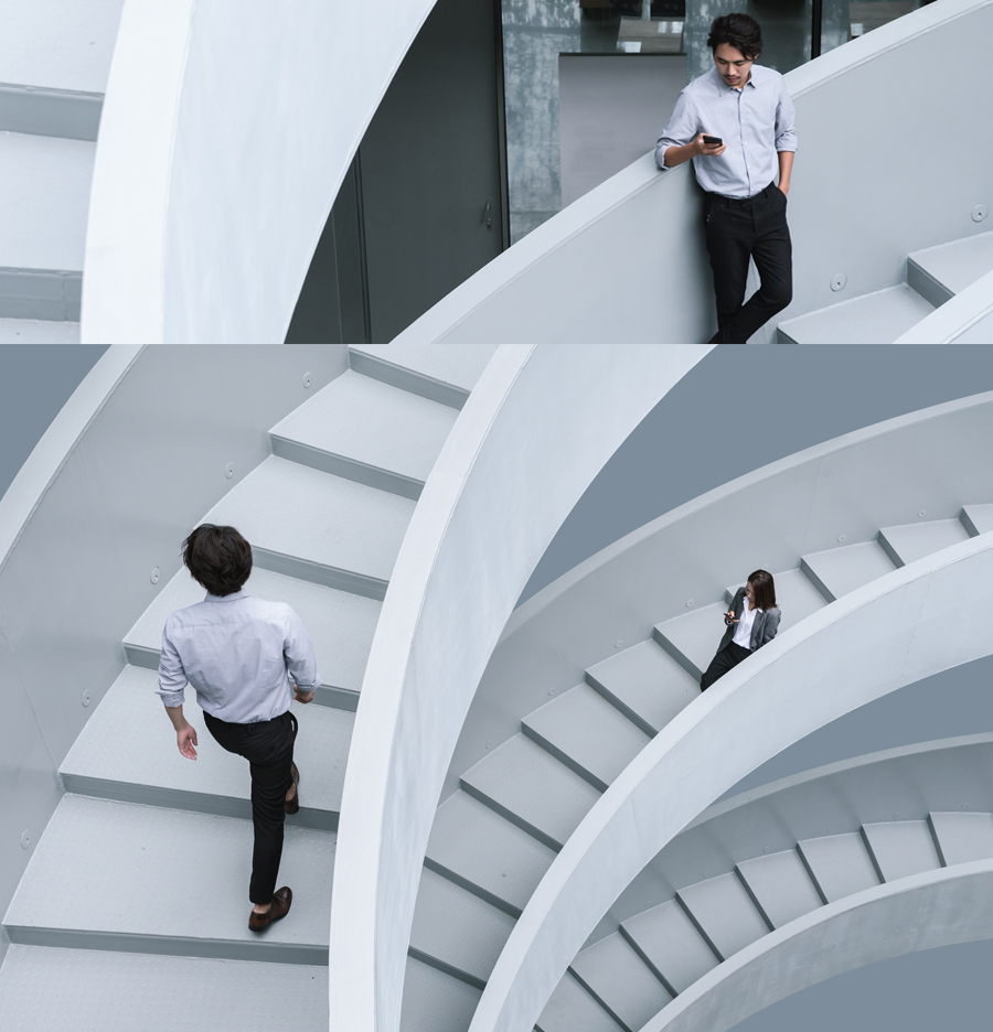 Business people walking up winding stairs.